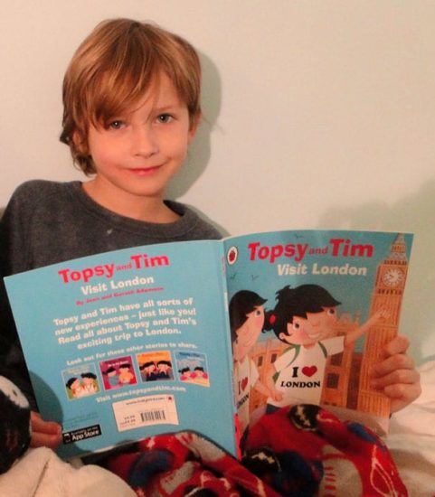 Theo reading children's book on London