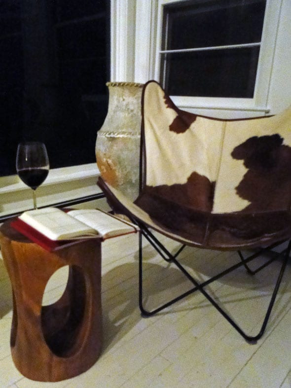 Diary, notebook and glass of wine by chair