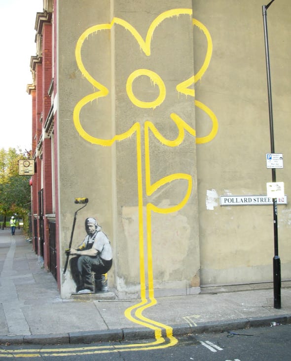 Banksy yellow flower on wall and street