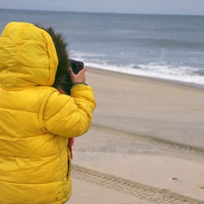 kid taking photos beach