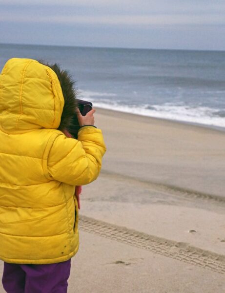 kid taking photos beach