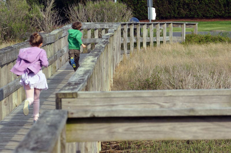 Luce and Theo running on boardwalk