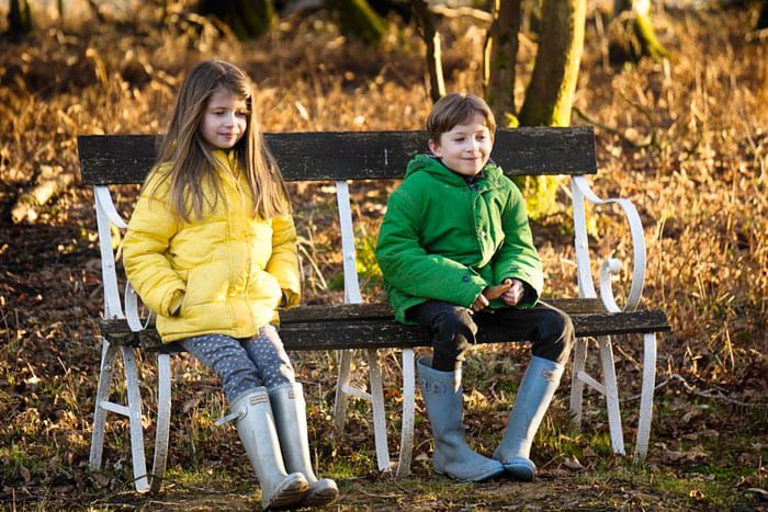 Luce and Theo on bench grinning