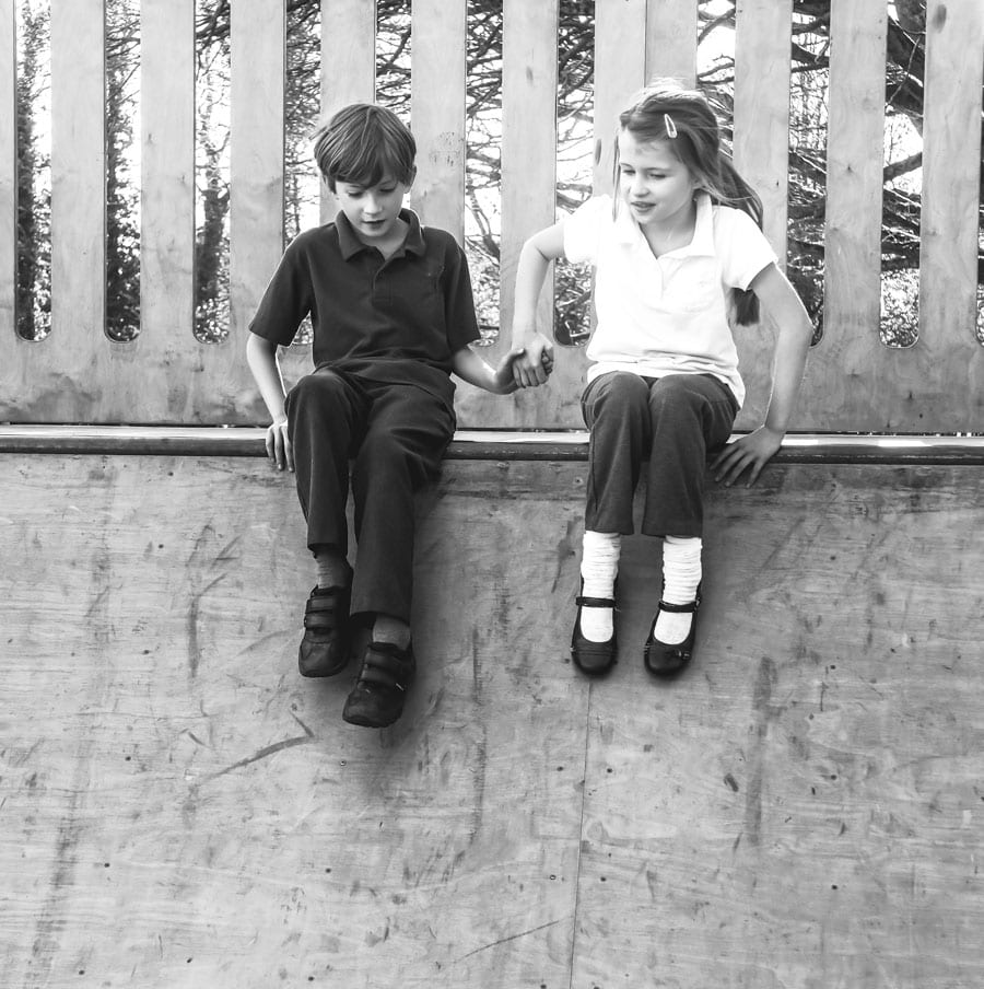 Holding hands on playground skateboard ramp