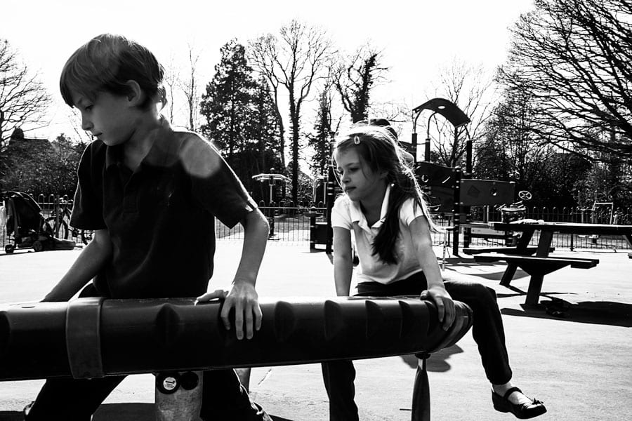 Luce and Theo swirling on playground donut