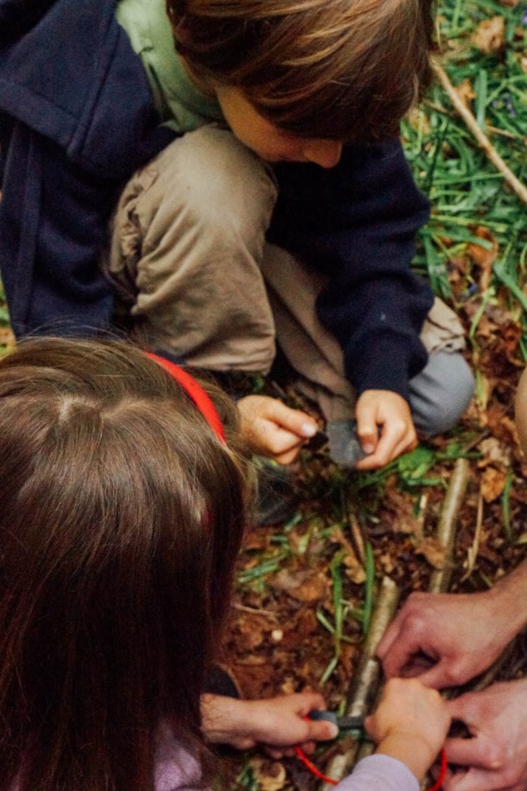 Luce and Theo learning how to light a camp fire