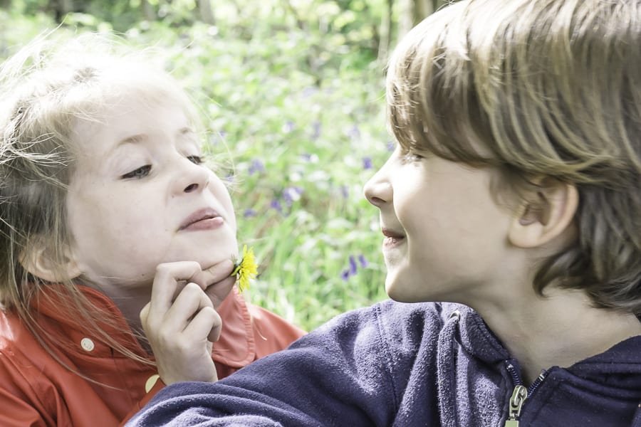 Luce and Theo with flower under chin