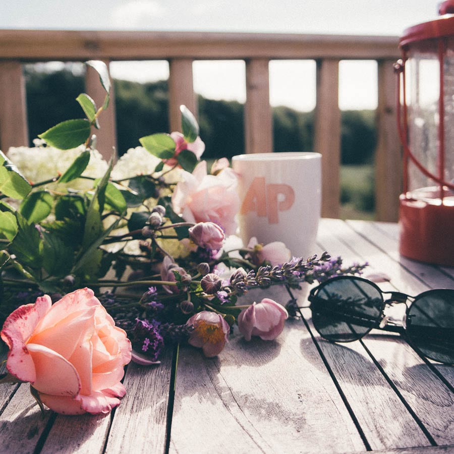 Summertime Flowers and sunglasses on deck table