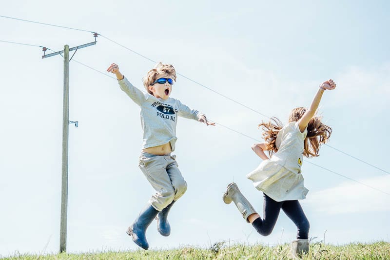 Twins in August leaping in joy