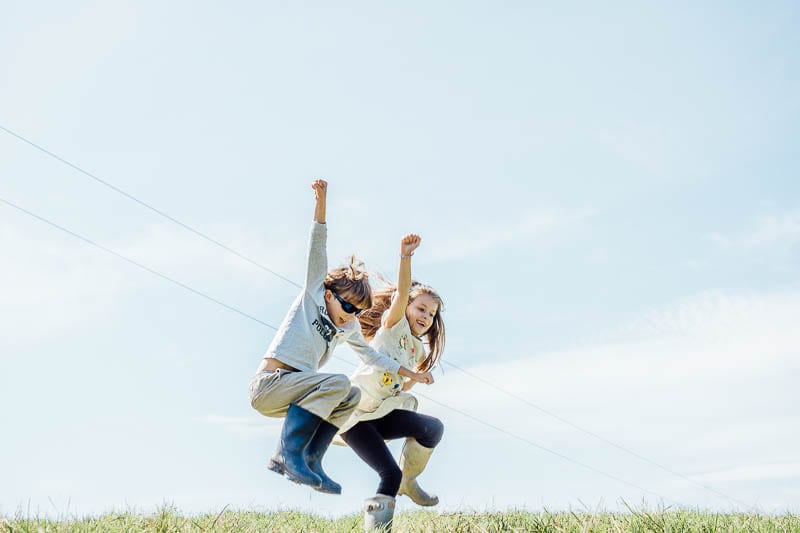 Twins in August leaping into air