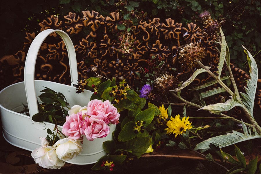 Roses flowers artichokes on garden bench